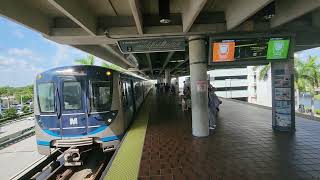 Miami Metrorail Northbound Orange Line train arriving and departing at Dadeland North Station.