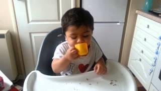 Baby Nirvan drinking milk from playset cup