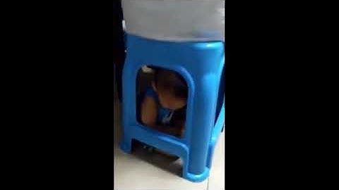 Cậu bé hơn 1 tuổi bị mẹ nhốt dưới gầm ghế rồi thản nhiên chơi bài.