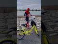 Spider-Man is riding a bicycle and picking up trash