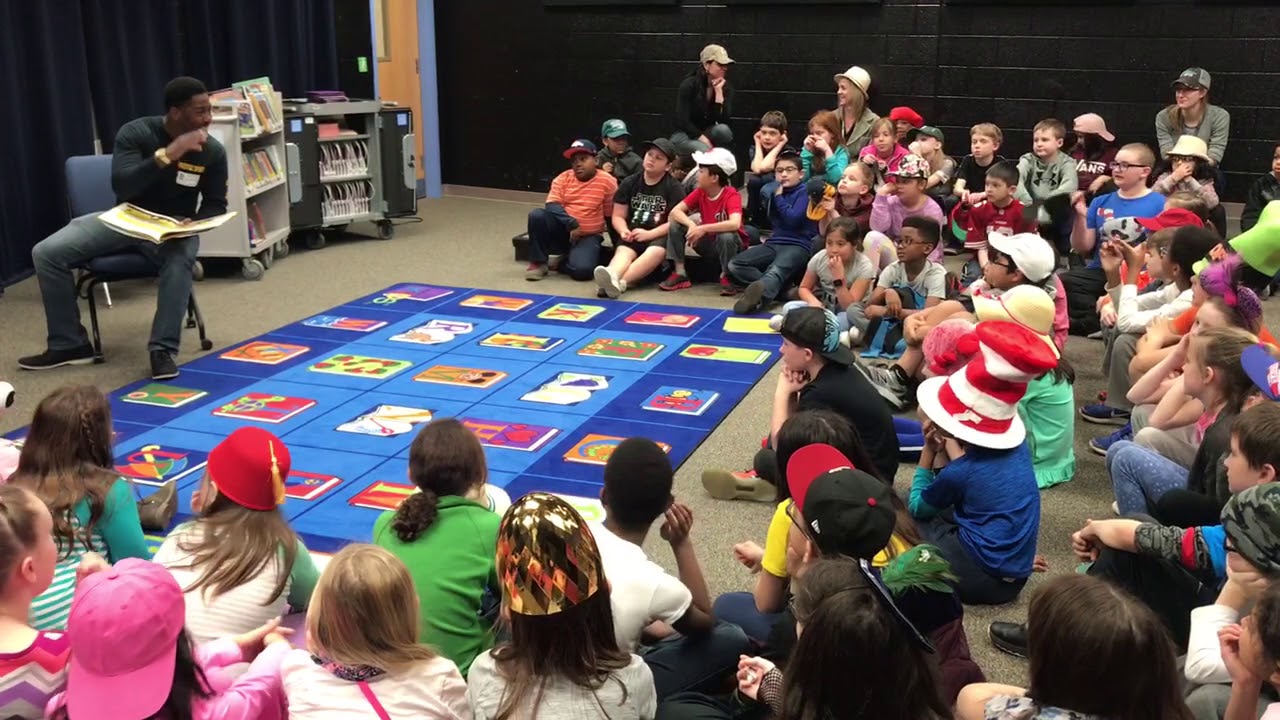 Coach Justin Ladson reads to 120 third graders at Ashland Elementary