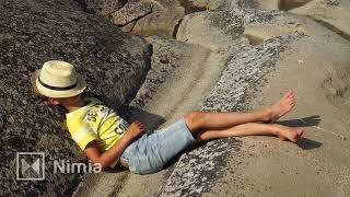 Boy With Summer Hat Relaxing On Cliffs In Bohuslän