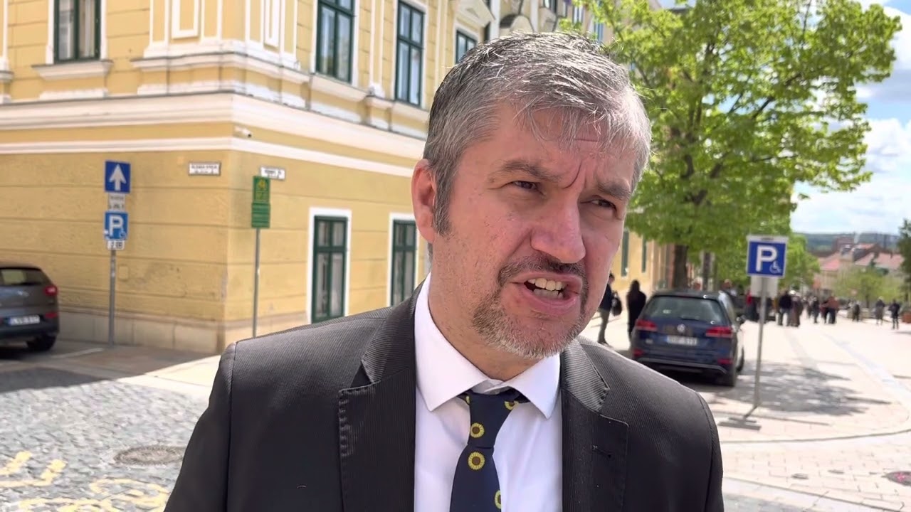 Hadházy Ákos a kordonbontás másnapján kormányplakátokat átragasztó jogvédő mellett állt ki