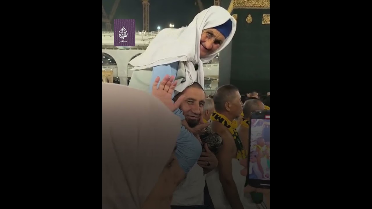 مشهد يأسر القلوب.. معتمر يحمل والدته المسنة على كتفيه ويطوف بها حول الكعبة