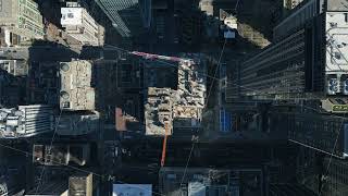Aerial perspective revealing a modern skyscraper under construction with a towering crane and