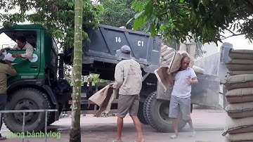 Ô-tô trừơng hải 8 tấn chở xi măng lùi vào ngõ hẹp,công nhân bốc vác xi măng làm việc
