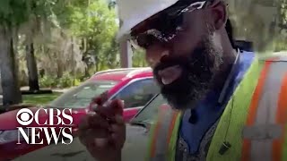 Utility worker sings to elderly woman social distancing outside