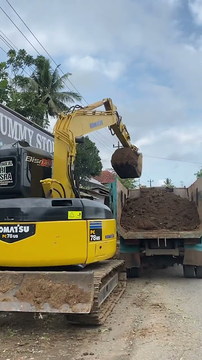 excavator digs the ground for the transport truck