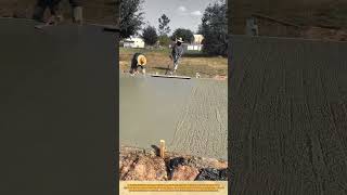 Leveling Fresh Concrete Slab with Bull Float for Smooth Surface Finish