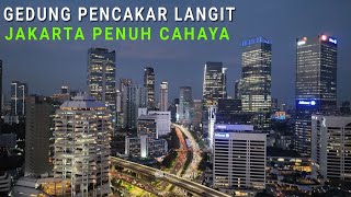 Terbang diantara Gedung Pencakar Langit Jakarta Yang Bercahaya di Malam Hari dengan Drone