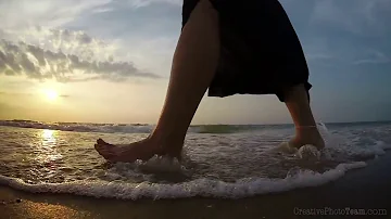 Barefoot legs of young female walking on the sunset beach, Biruchiy island,Ukraine