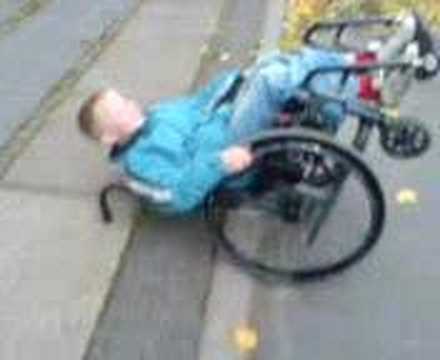 little boy doing wheelie on a wheel cheir