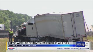 Crews work to remove submerged 18 wheeler