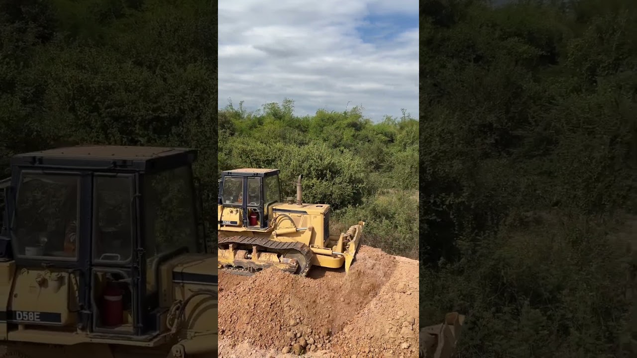 Pushing and leveling soil around the concrete utility pole by a big bulldozer.