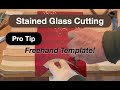 Cutting difficult red stained glass with a hard curve and point with a template.