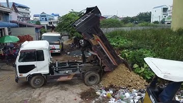 Nicely landfill by skilled D31P Dozer push stone and Dump Trucks unloading