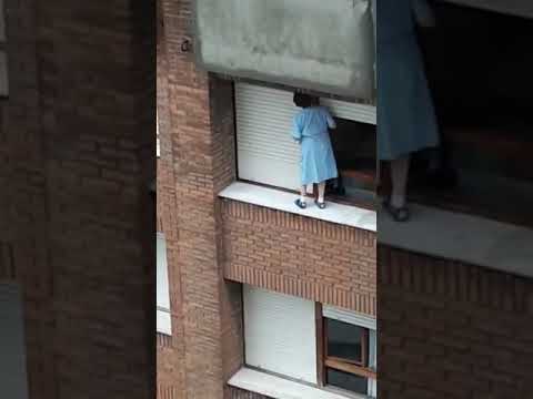 Una mujer que se balancea en la cornisa de un séptimo piso para limpiar las ventanas