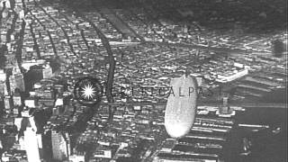 Dirigible USS Akron during its first flight over buildings, river bridges and Man...HD Stock Footage