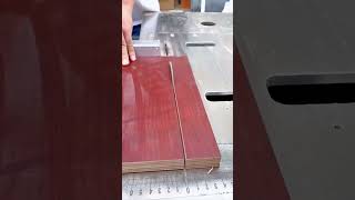 cutting the brown wooden plywood board using a circular table saw machine in the workshop area