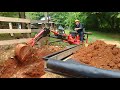 Harbor Freight towable trencher/backhoe loading a trailer.
