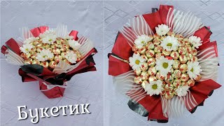 Шикарний букет з цукерок та квітів ромашок на підставці.