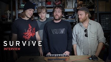 The members of S U R V I V E check out the Monologue