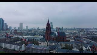Frankfurter Dom. Historic gothic church between buildings in town centre. Overcast sky above city
