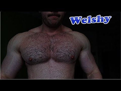 Young bodybuilders huge pumped up hairy chest while training