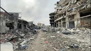 Palestinians walk along destroyed streets in Gaza City | AFP