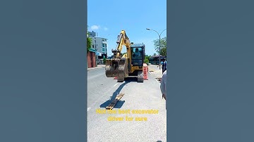 Amateur excavator driver unloading from trailer ramp