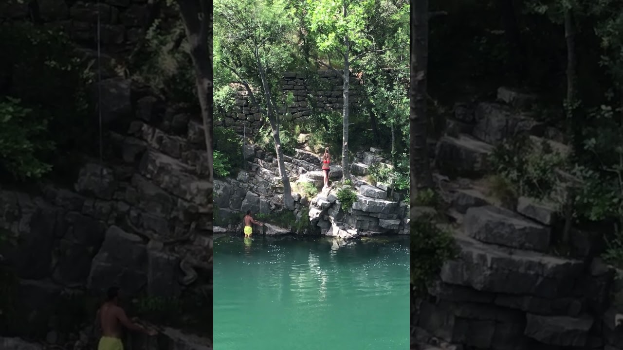Girl on rope swing let's go too early and falls in the water