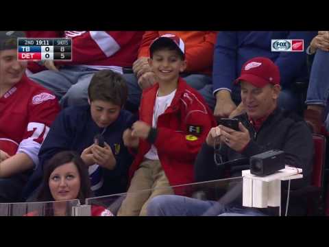Peter Budaj catches a puck from the bench and gives it to young fan