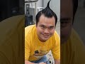 太った男が、壊れたロボットを修理しようとしている。