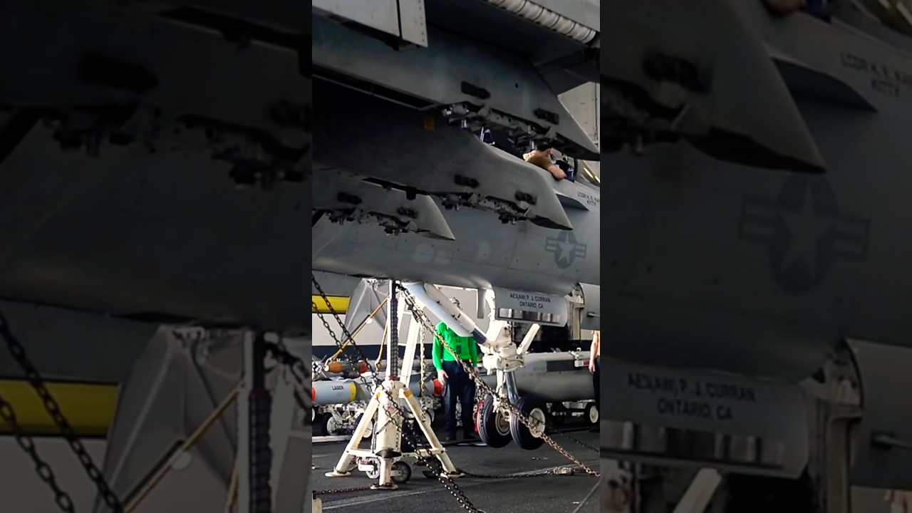 Maintenance on the wheels of an F/A-18F Super Hornet fighter jet