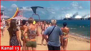Russians relaxing on the beach watch in fear the explosions on the Crimean bridge