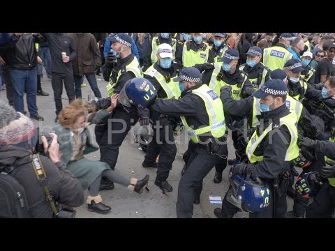 Woman thrown to the ground as police officers scrap with anti-lockdown protesters in London