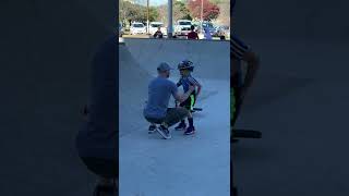 Boy rides bike up half pipe and falls on back of head