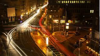 Fast Day to Night Time Lapse of City Street intersection with busy car traffic and office building