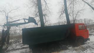 Грузовик КАМАЗ застрял в грязи, достает трактор МТЗ