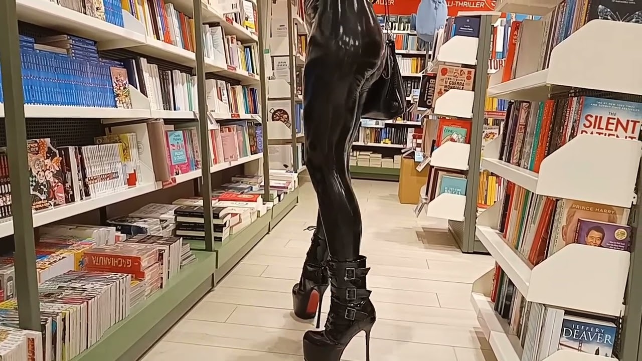 DANA LABO -   blonde girl with bangs, walking in high heel boots, shiny wet look leggings