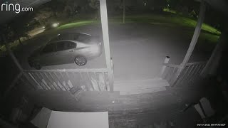 Surveillance video | Gunshots sound as car drives past home with elderly woman inside