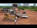 Great Processing Bulldozer Using Technique to Push Rock Out From Dump Truck