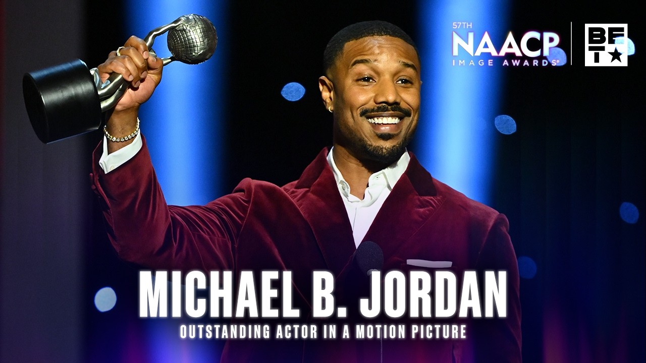 Michael B. Jordan stands on stage at the NAACP Image Awards ’26 holding his Outstanding Actor award, delivering an emotional speech dedicated to Chadwick Boseman, reflecting on his legacy and influence in film and culture.