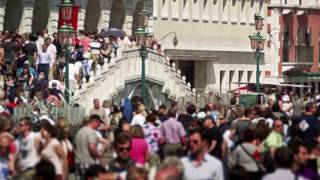 Slow motion shot of crowds walking across pedestrian bridge