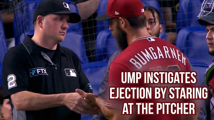 Umpire stares at Bumgarner while massaging his han...