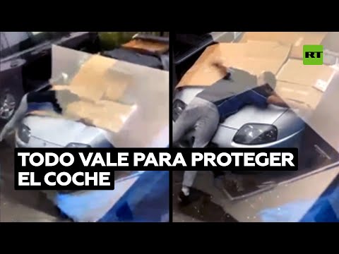 🌨️ Un hombre protege su coche deportivo del granizo con el cuerpo