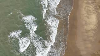 Vue aérienne verticale des vagues sur la plage de sable
