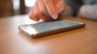 No copyright man scrolling phone on table | Using iphone | Free stock footage | Creative commons