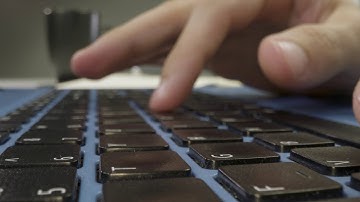 Sliding Extreme Close Up Shot of Male Hands Typing On a Laptop Keyboard