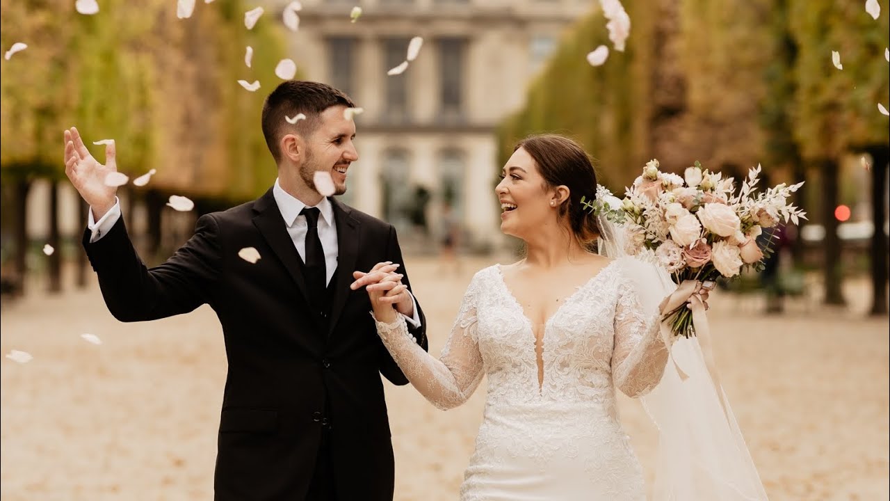 Bride and groom in a Paris garden laugh under falling petals, hand in hand